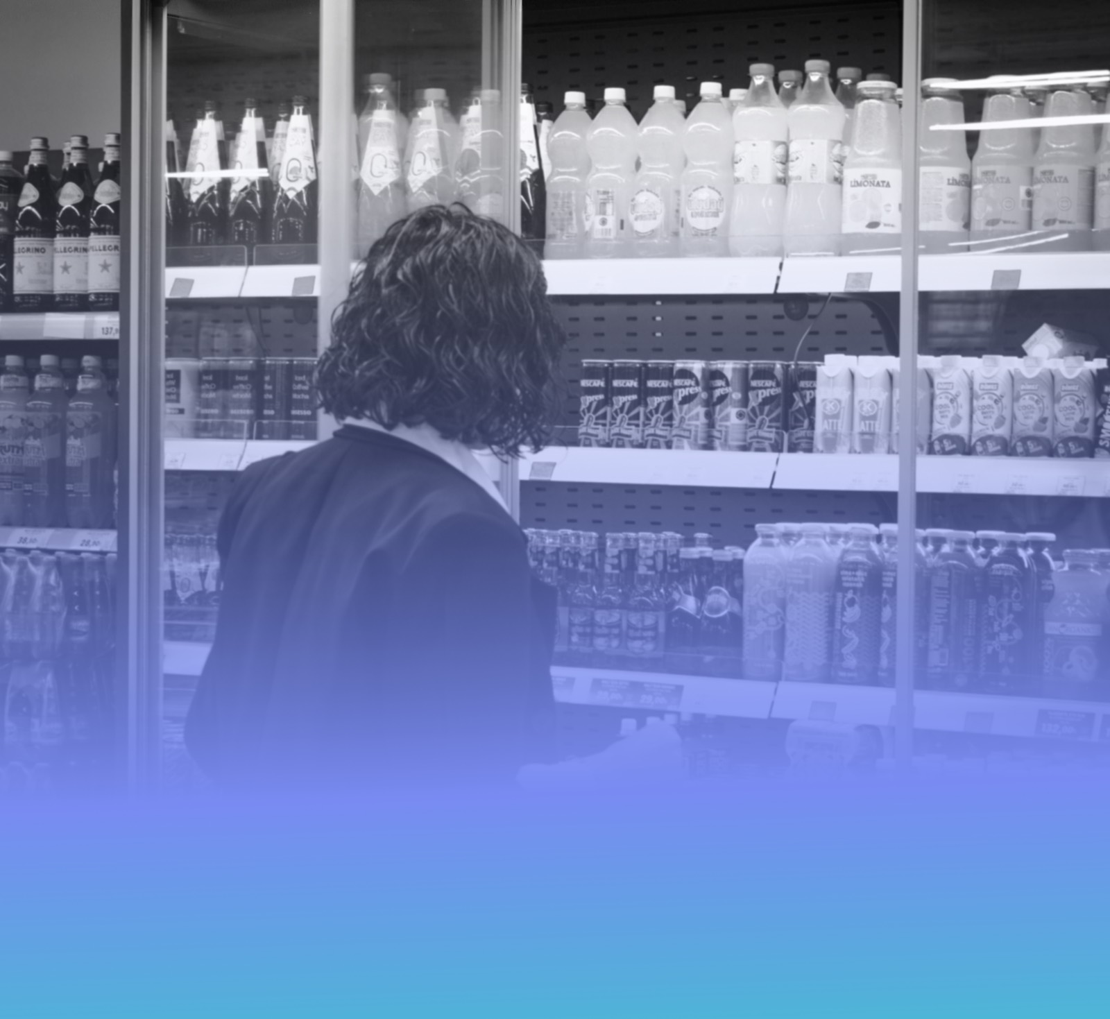 A shopper browsing bottled drinks in a store fridge